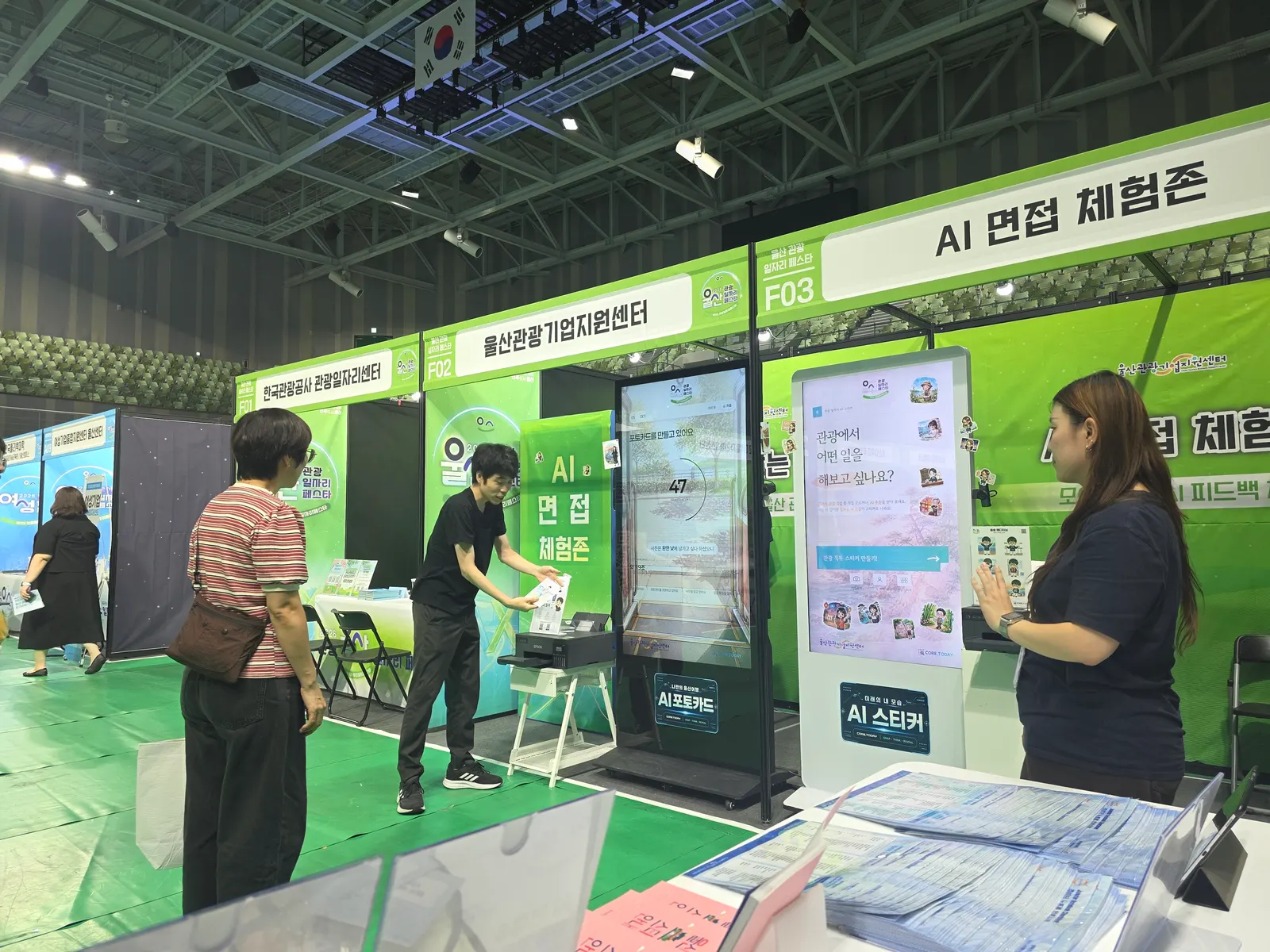 울산관광기업지원센터 부스의 AI 포토카드와 AI 스티커 키오스크, 인쇄된 포토카드를 건네는 스태프