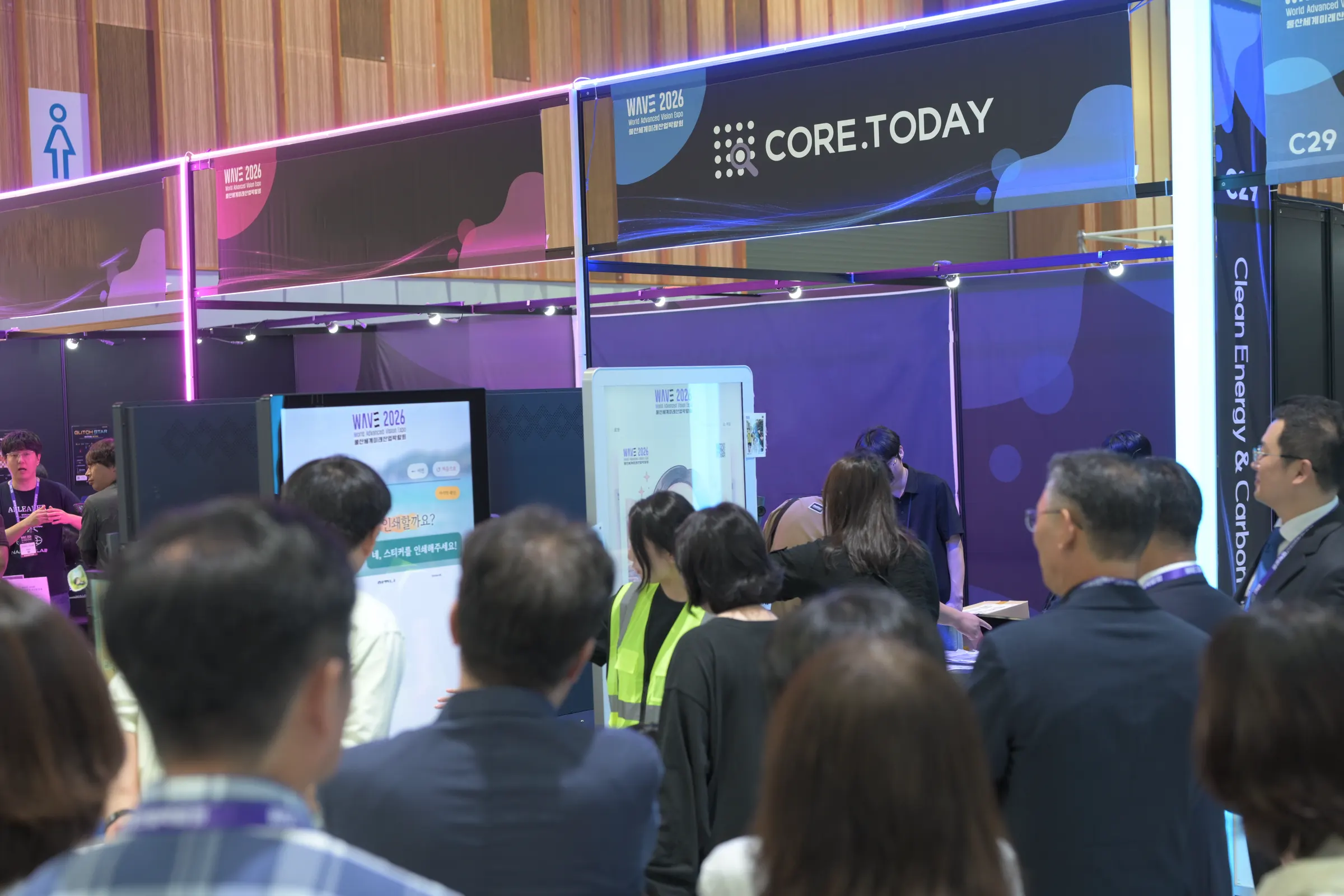 WAVE 2026 CORE.TODAY 부스 앞에 모여 키오스크 체험을 지켜보는 관람객
